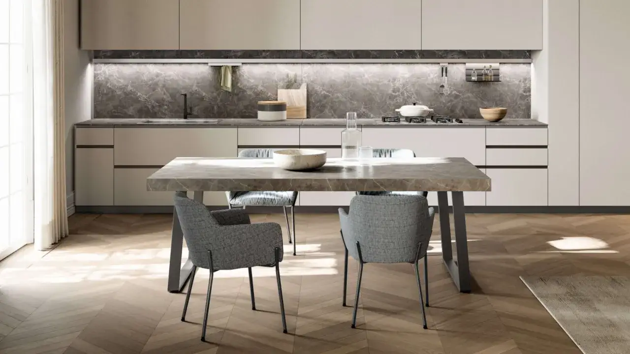 Tavolo da pranzo moderno con piano in marmo e sedie grigie. L'altezza del tavolo da pranzo è perfetta per la zona cucina.