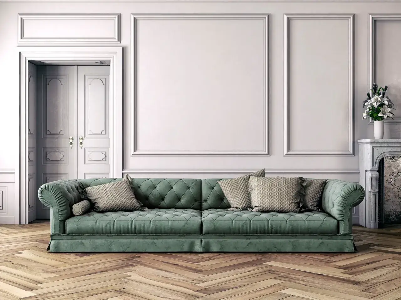 Divano verde foresta imbottito, con cuscini decorativi, su un parquet in legno. Parete bianca con boiserie e porte a battente.