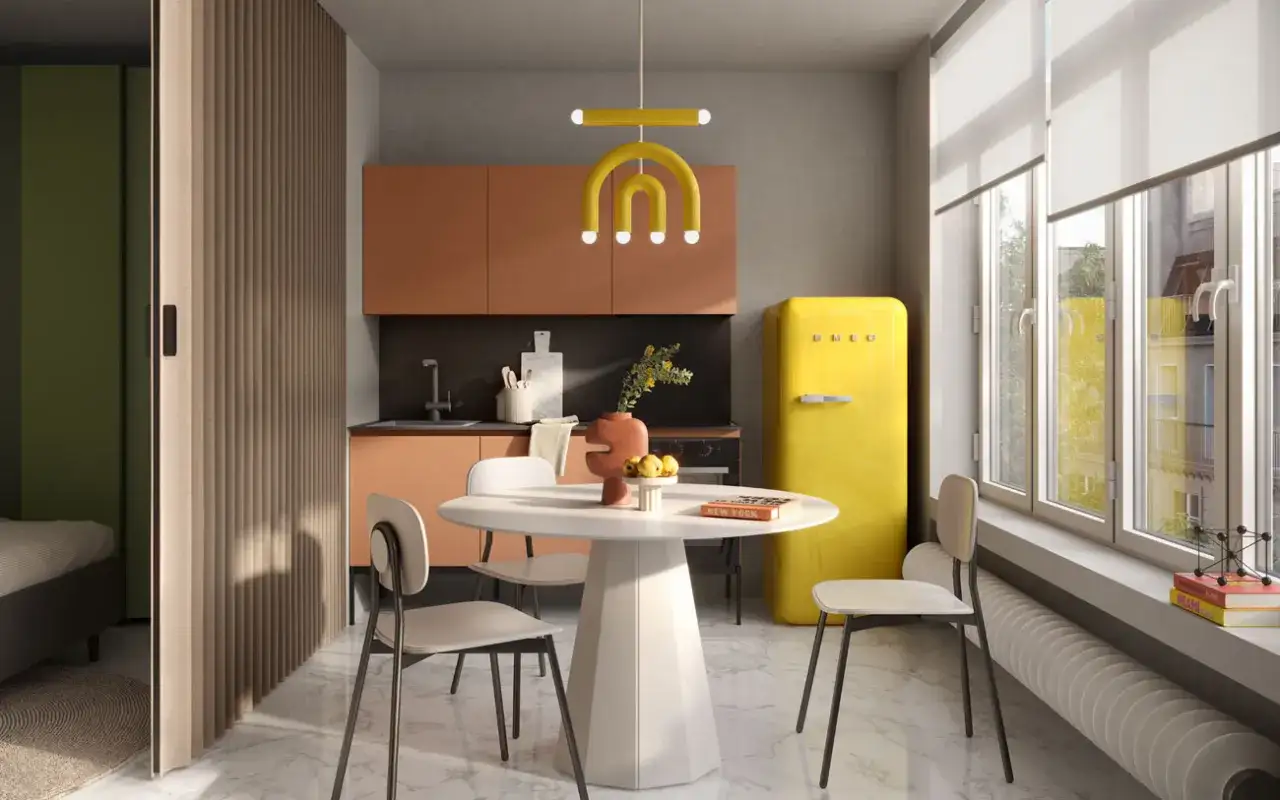 Un'elegante cucina e camera da letto insieme, con un frigorifero giallo acceso, mobili color pesca e un divisorio in legno che separa gli ambienti.
