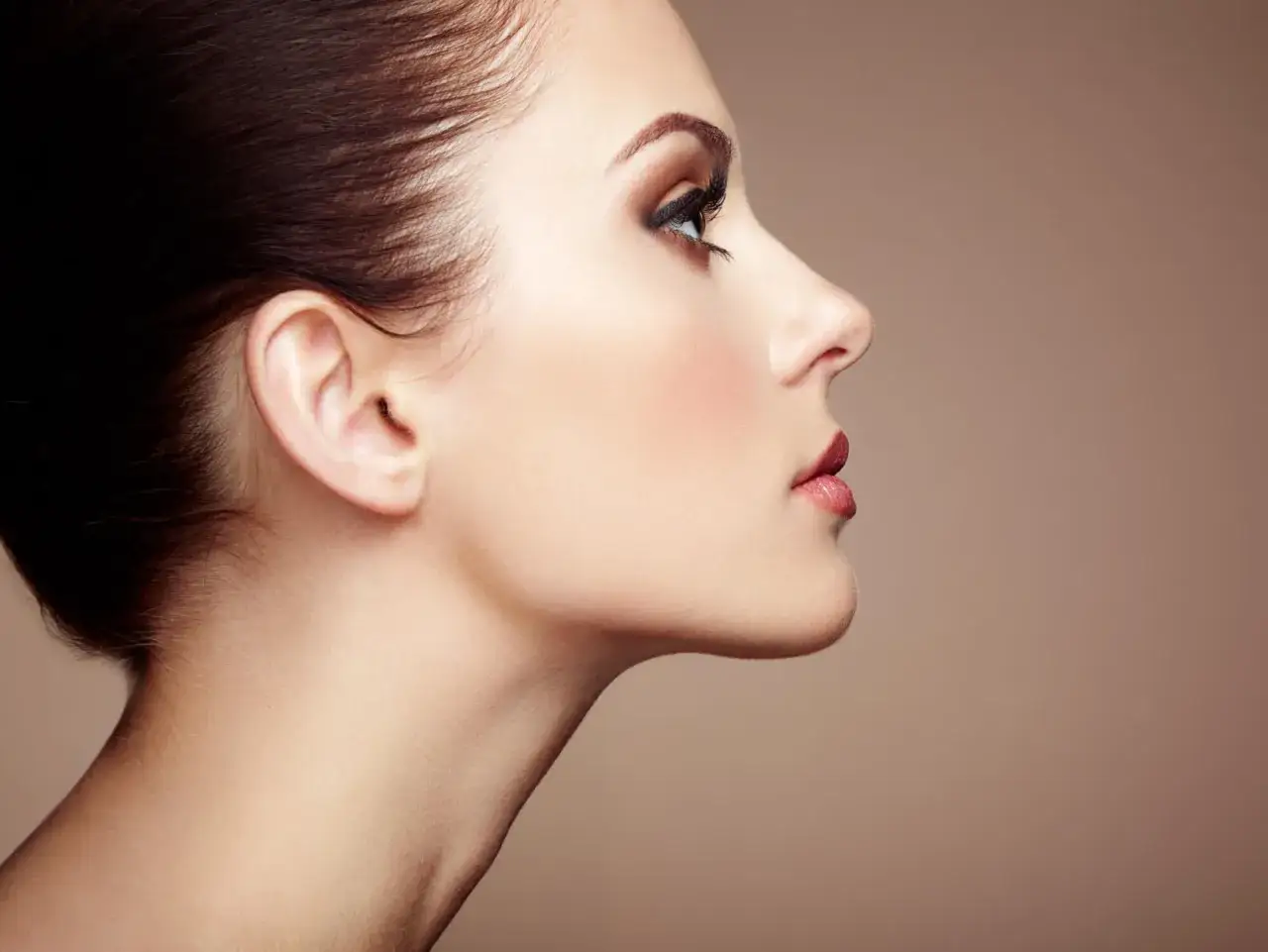 Profilo di donna con trucco impeccabile e collo elegante, senza alcun segno di doppio mento.