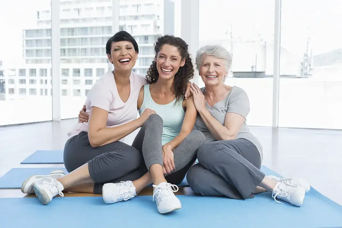 Tre donne di et&agrave; diverse ridono insieme, un simbolo di empowerment femminile e di forza condivisa.