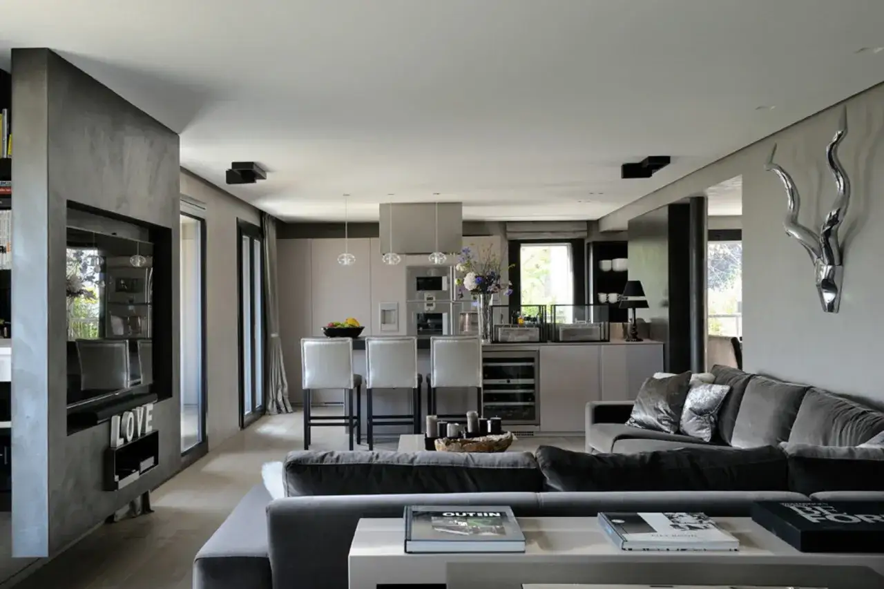 Soggiorno moderno con cucina a vista, divano ampio e decorazioni di design. Ottime idee arredamento casa per uno stile contemporaneo.