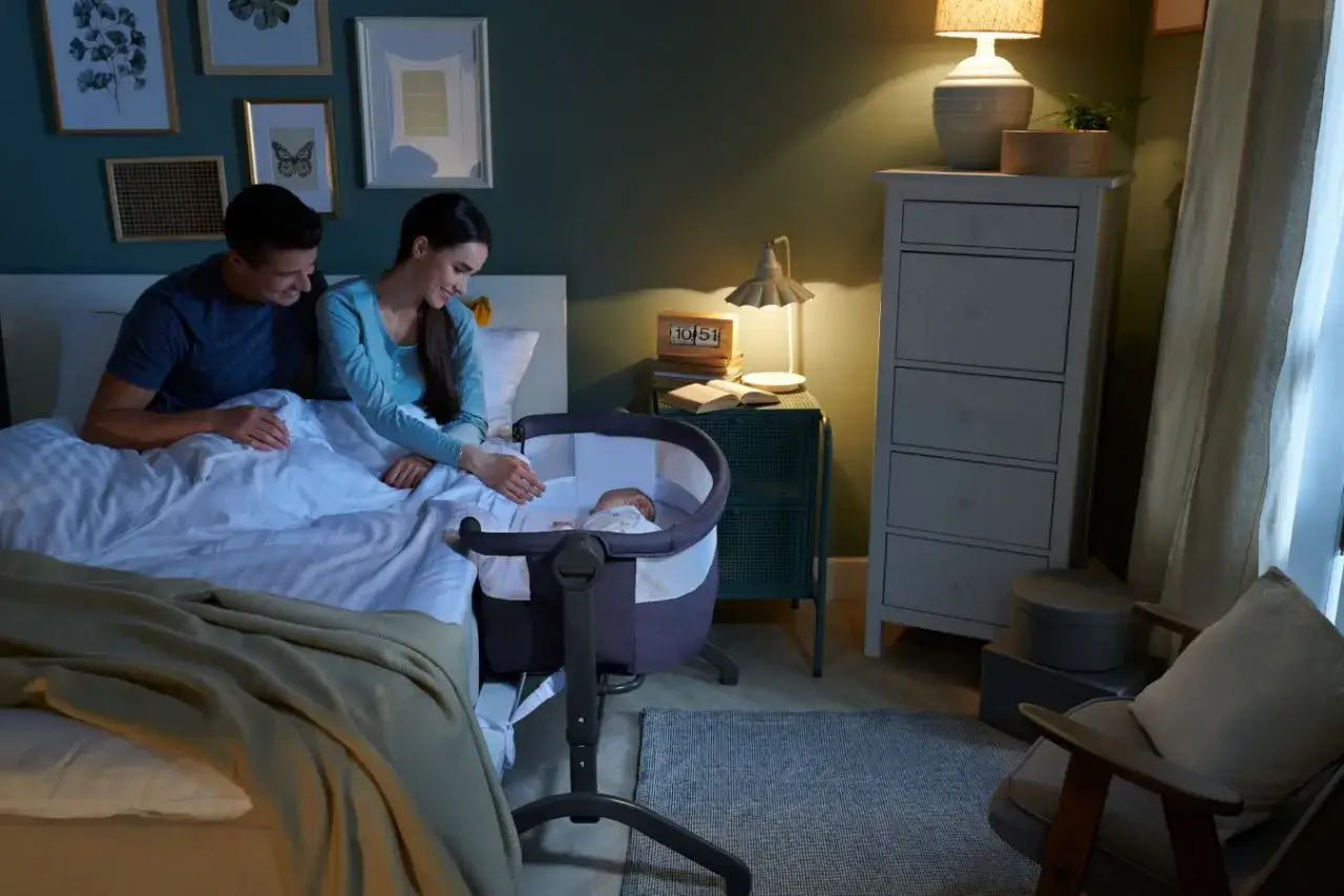 Cozy bedroom scene with parents watching their newborn in a bassinet. Everything you need for a newborn, including a comfortable bed and a loving family.