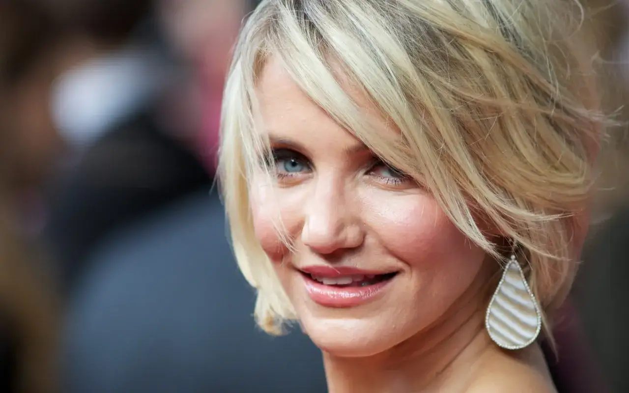 Cameron Diaz con un taglio scalato che valorizza le acconciature capelli fini, un sorriso smagliante e un orecchino a goccia.