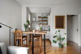 Soggiorno e cucina in stile nordico, con tavolo in legno e sgabelli, un tocco di stile scandinavo.