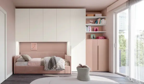 Camera ragazza aesthetic con letto rosa, armadio bianco e rosa, libreria con libri e decorazioni, pouf e grande finestra.